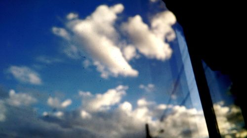 Low angle view of airplane flying against blue sky