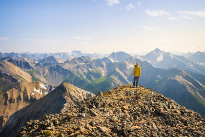 Rear view of man on rock against sky