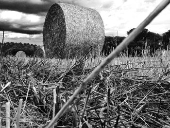 View of field against cloudy sky