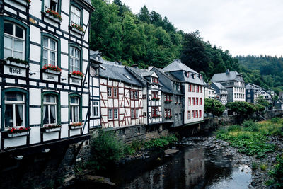 Buildings by river against sky