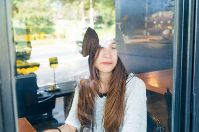 Woman sitting in restaurant seen through window