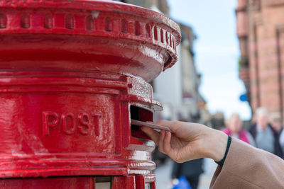 Close-up of hand holding red mailbox