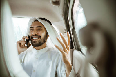 Portrait of young man sitting in car