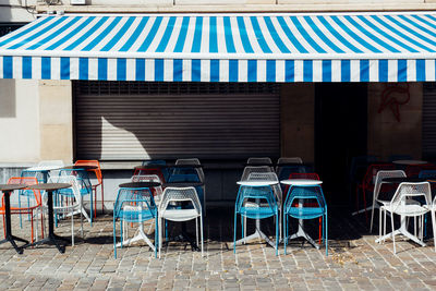 Empty chairs and tables in city