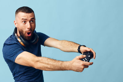 Portrait of young man exercising against white background