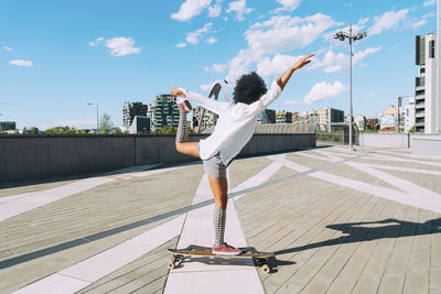 Young woman longboard dancing in city