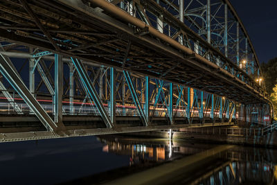 Bridge over lake against sky at night