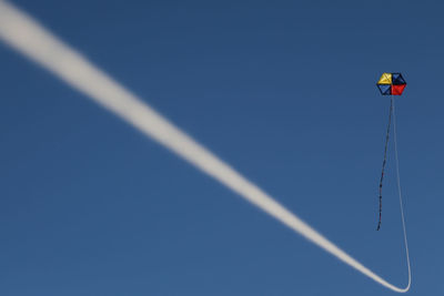 Low angle view of trees against clear blue sky