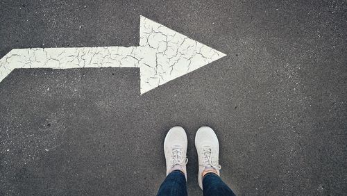 Low section of person standing on road