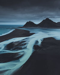 Scenic view of sea and mountains against sky