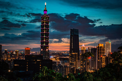 Illuminated buildings against sky at night