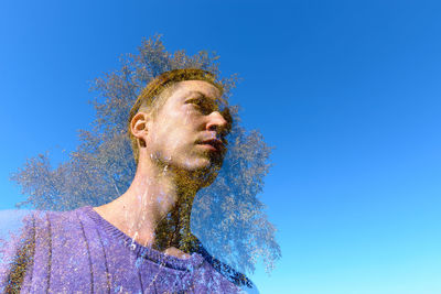 Low angle view of man against blue sky