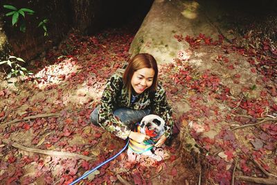 Portrait of smiling woman with dog during autumn