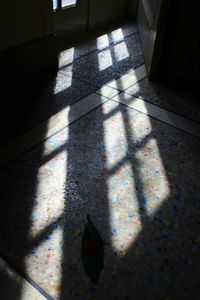 High angle view of sunlight falling on tiled floor