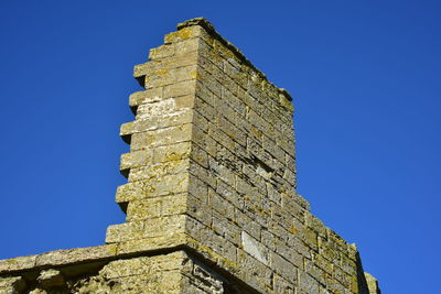 Low angle view of castle against clear blue sky