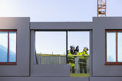 Two engineers high fiving at construction site