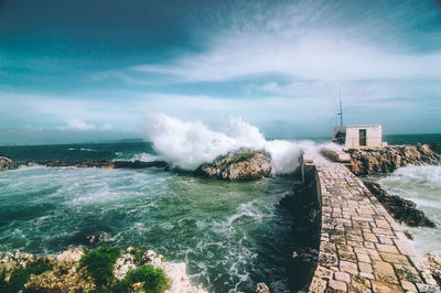 Waves splashing on sea against sky