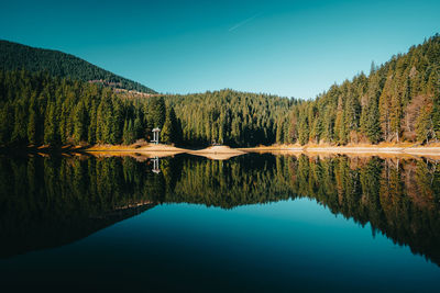 Scenic view of lake against clear blue sky