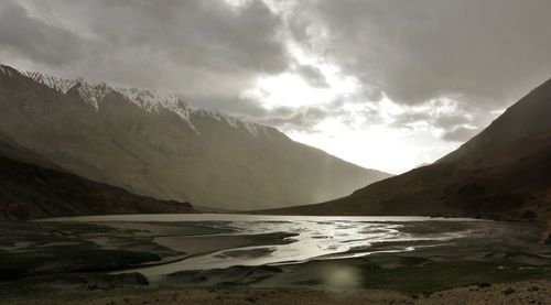 Scenic view of river and mountains against sky