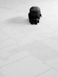 Rear view of man kneeling on floor