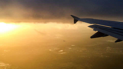 Cropped image of airplane against sky at sunset