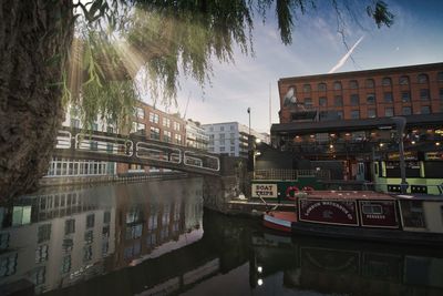 Canal amidst buildings in city against sky