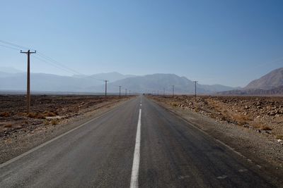 Road leading towards mountains against sky