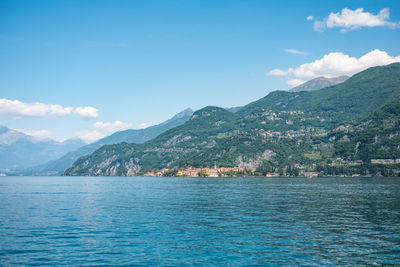 Scenic view of sea and mountains against blue sky