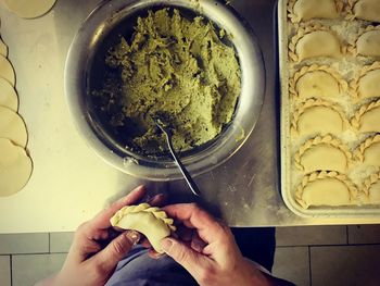 Midsection of person preparing food in kitchen at home