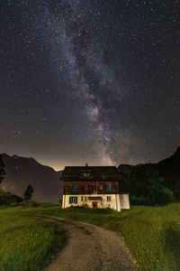 House on field against sky at night