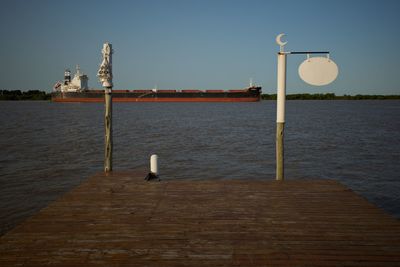 Street light on pier by sea against clear sky