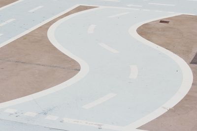 High angle view of arrow sign on footpath