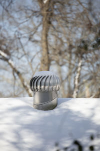 Shiny, snow-dusted whirlybird air vent on a snow-covered roof