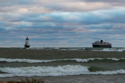 Lighthouse by sea against sky