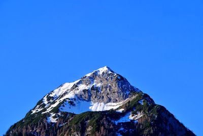 Low angle view of rocky mountains against clear sky