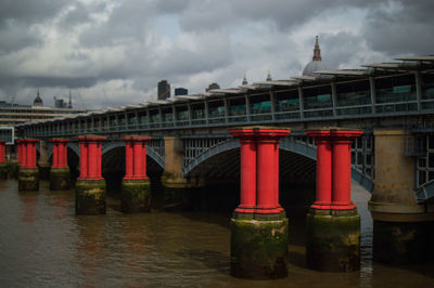Red bridge over river against sky