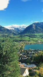 Scenic view of townscape by mountains against sky