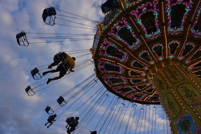 Low angle view of chain swing ride against sky