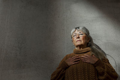 Portrait of woman standing against wall