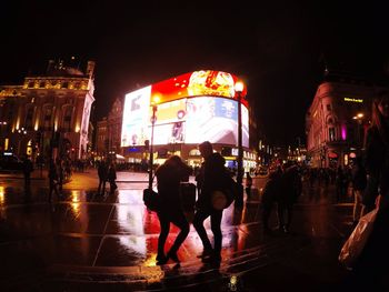 Woman standing in illuminated city at night