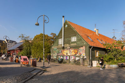 People on street by buildings against sky