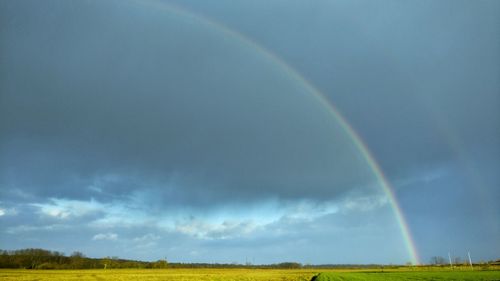 Rainbow over field against sky