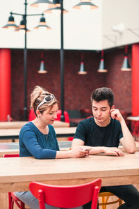 Mother and son using mobile phone at restaurant