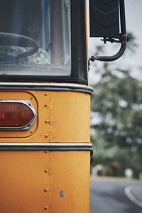 Close-up of yellow car on street