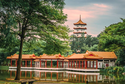 View of building by lake against sky