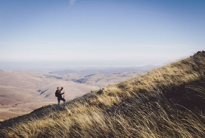 Man standing on landscape against clear sky