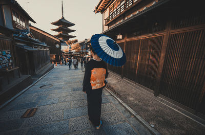 Woman standing on footpath in city