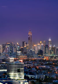 Illuminated buildings in city against sky at night