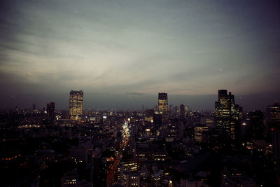 Illuminated cityscape against sky at night