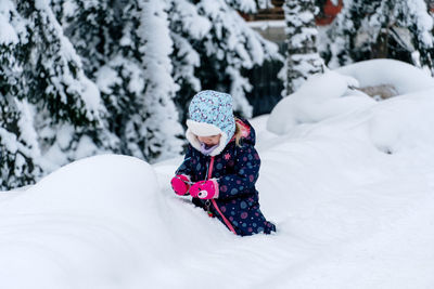 Rear view of woman skiing on snow covered field